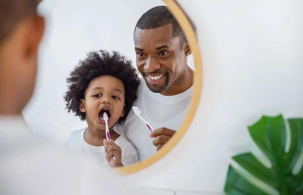 Child-sized hygiene tools including a step stool and toothbrush in a bright bathroom.