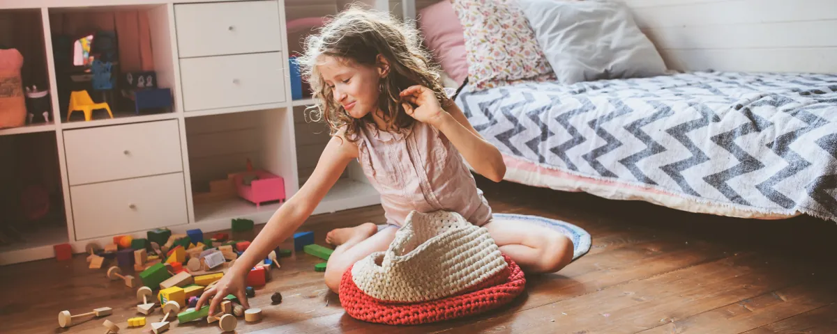 A clean playroom floor with toys returned to bins indicates successful cleaning habits.