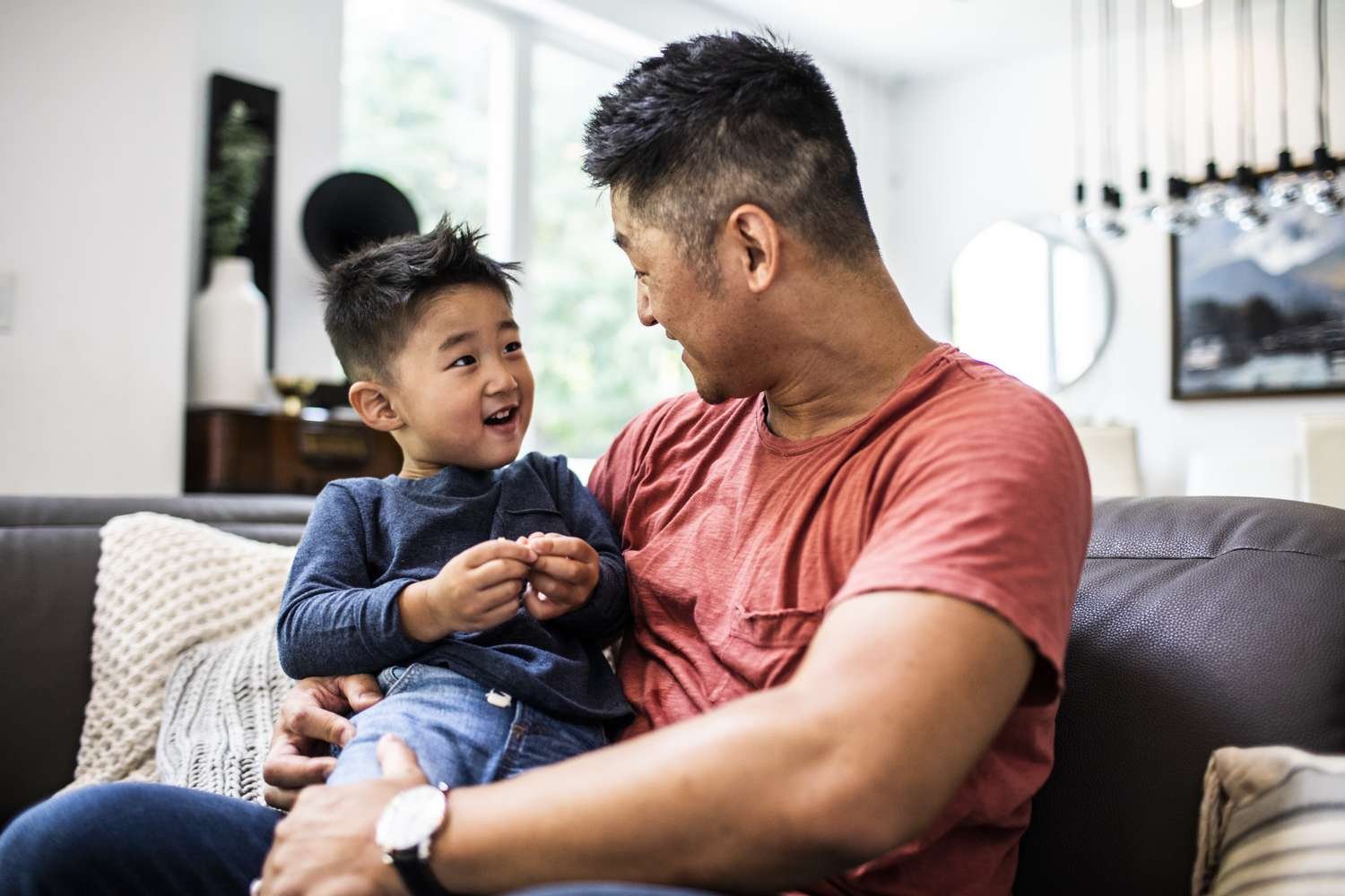 A parent kneels to talk calmly at eye level with a toddler.