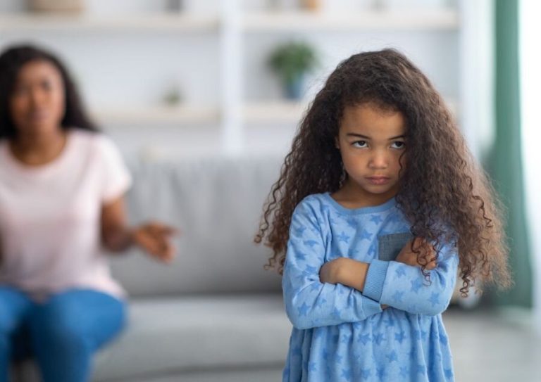 A parent calmly communicating with their toddler to encourage better listening skills.