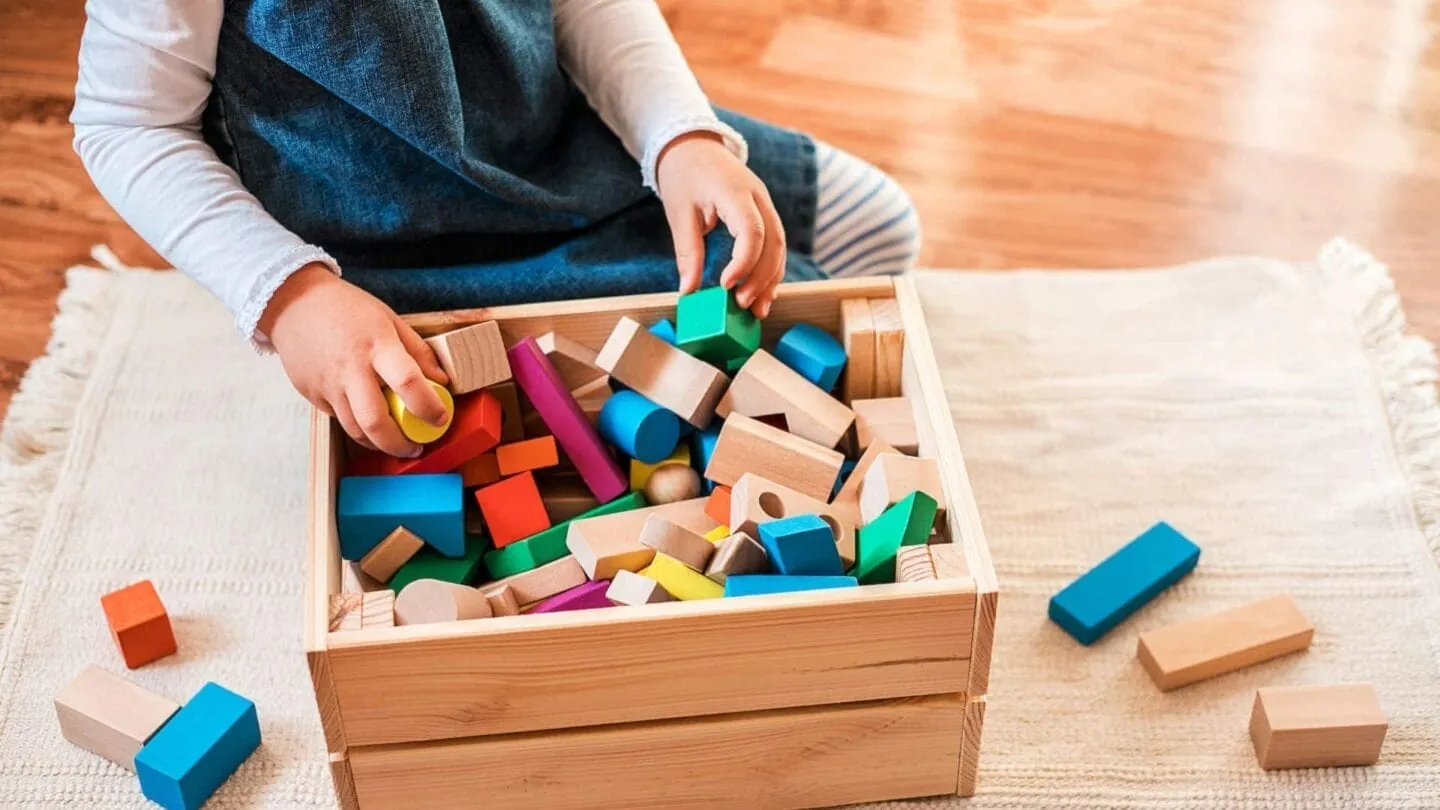 A parent reviews cleaning progress in a bright and well-organized children's playroom.