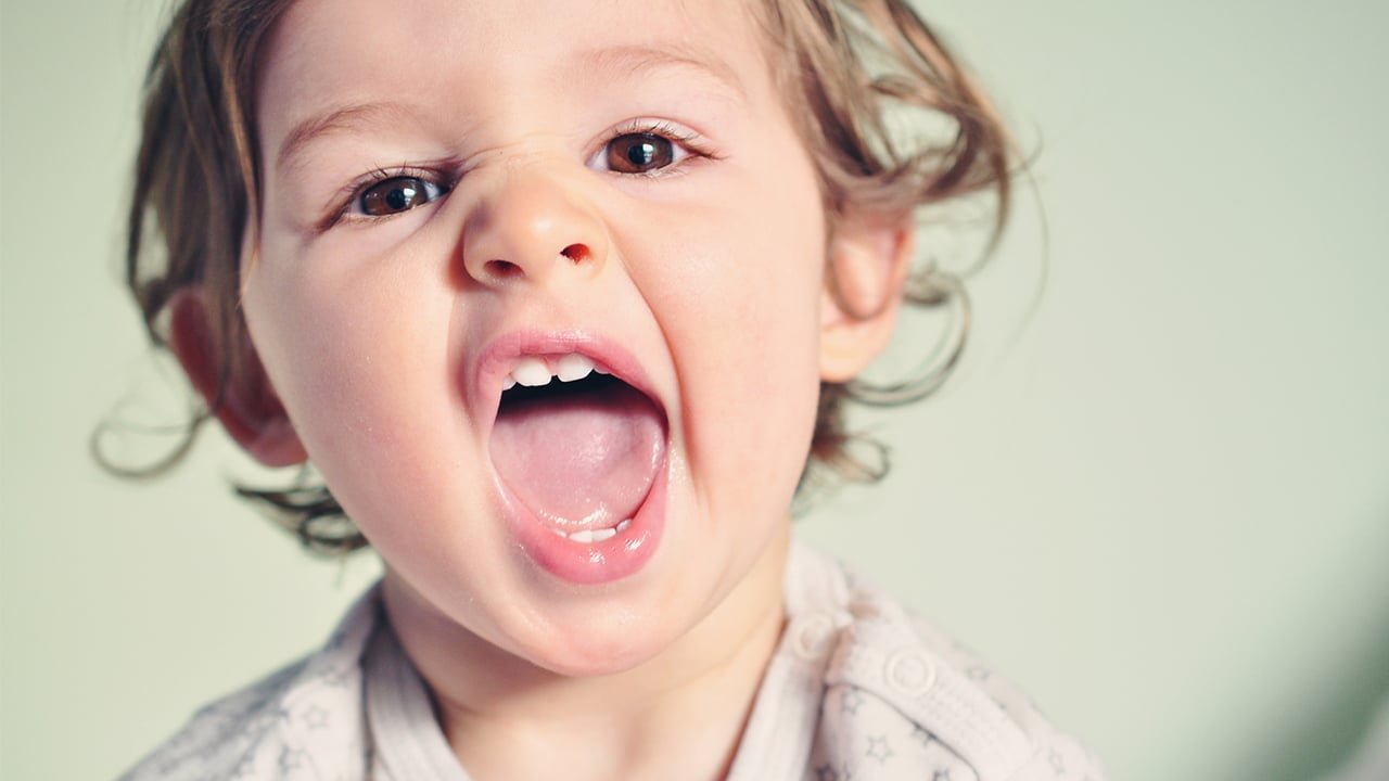 A caregiver calmly guides a toddler away from a situation to teach boundaries.